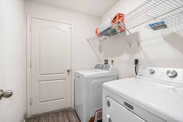 clothes washing area featuring hardwood / wood-style flooring and washing machine and clothes dryer