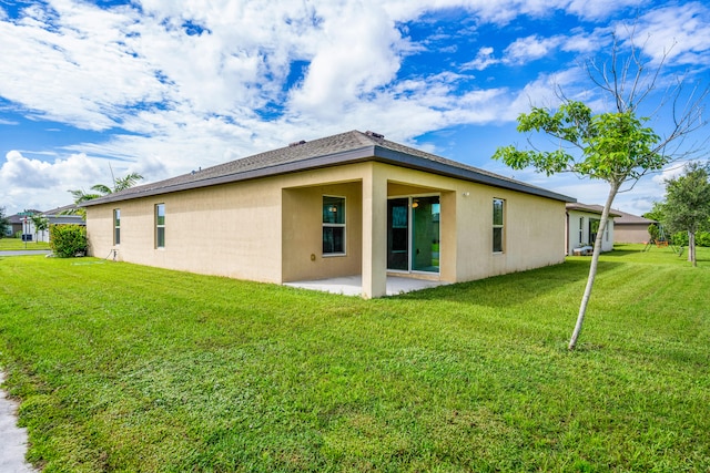 back of house featuring a lawn and a patio