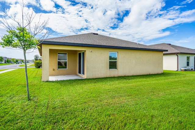 rear view of property with a yard and a patio area