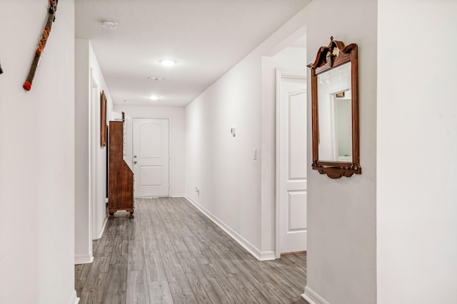 corridor featuring a textured ceiling and light wood-type flooring