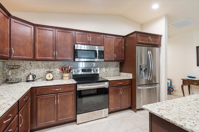 kitchen with stainless steel appliances, light stone countertops, backsplash, and vaulted ceiling