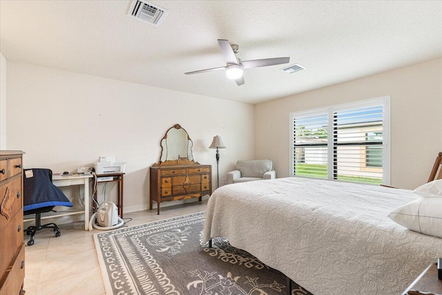 tiled bedroom with ceiling fan and a textured ceiling