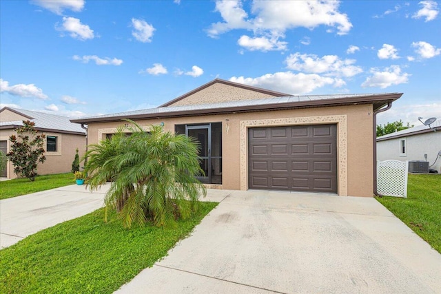 single story home with central air condition unit, a garage, and a front yard