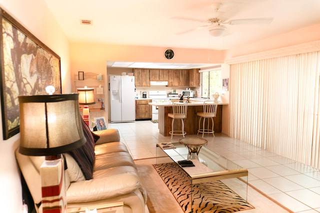 living room with ceiling fan, sink, and light tile patterned floors