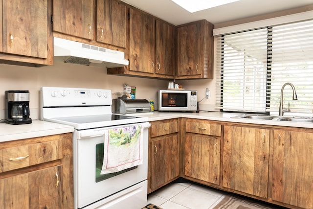 kitchen featuring white appliances, light tile patterned flooring, and sink