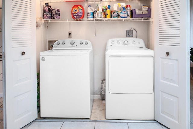 laundry area featuring light tile patterned floors and washing machine and dryer