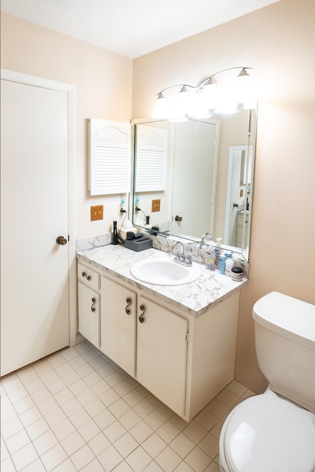 bathroom with tile patterned flooring, vanity, and toilet