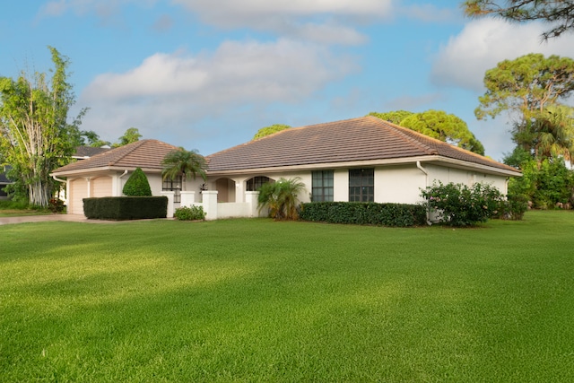 view of front of house featuring a front lawn and a garage