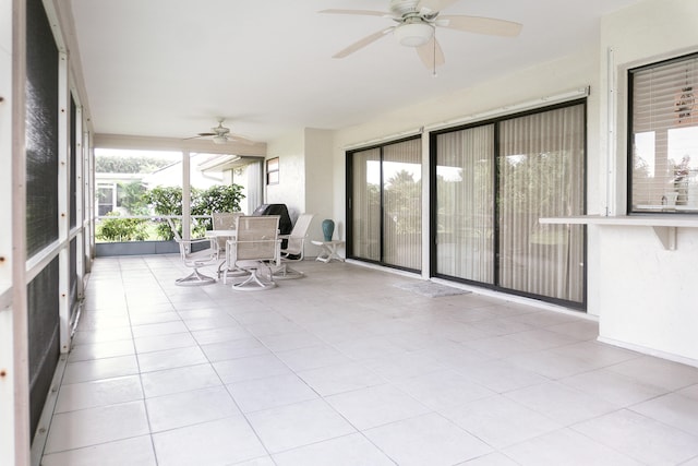 unfurnished sunroom featuring ceiling fan