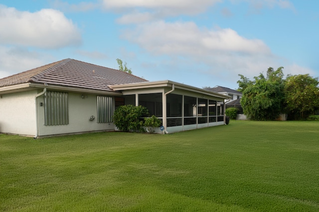 rear view of house with a sunroom and a lawn