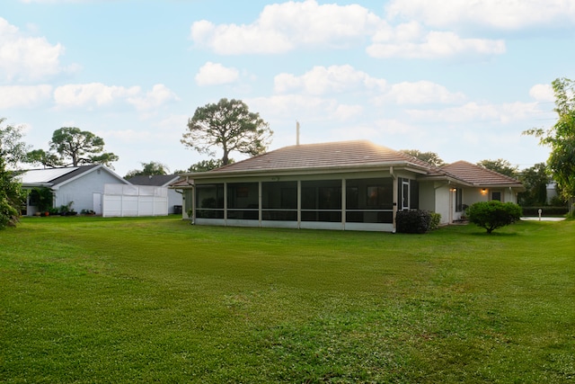 back of property featuring a yard and a sunroom