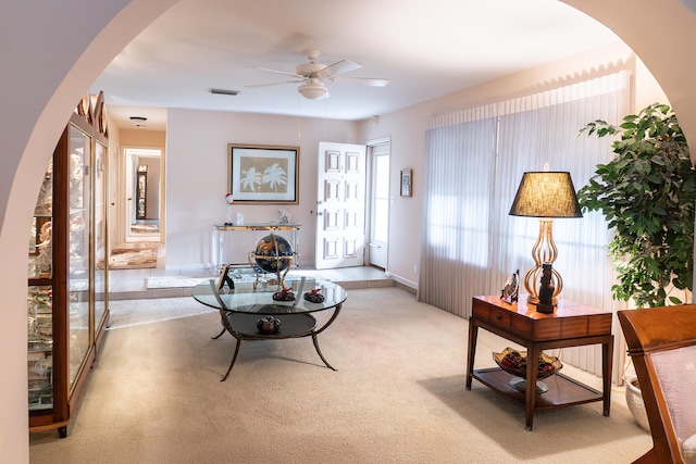 carpeted living room with ceiling fan