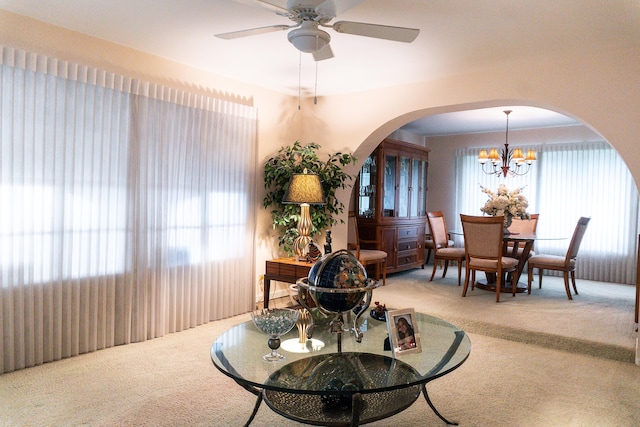 dining room with ceiling fan with notable chandelier and carpet floors