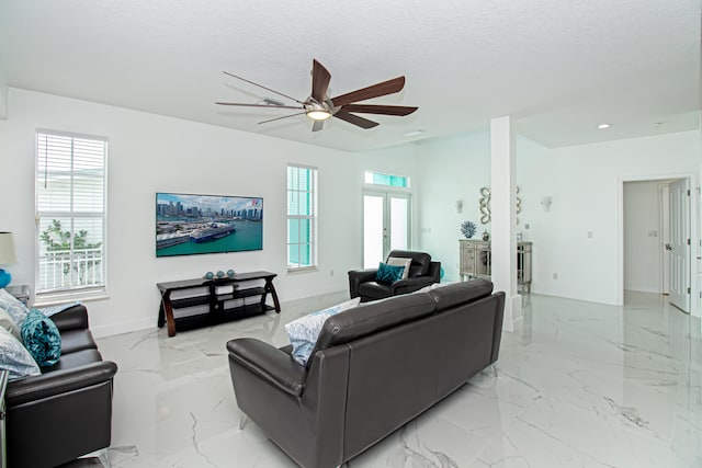 living room with french doors, ceiling fan, and a textured ceiling