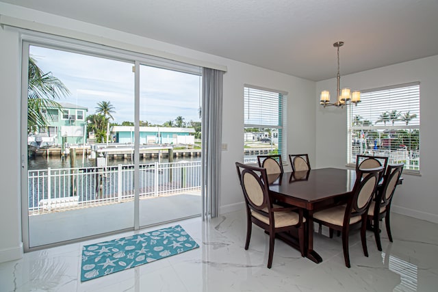 dining space with a water view and an inviting chandelier