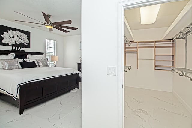 bedroom featuring a closet, ceiling fan, and a walk in closet