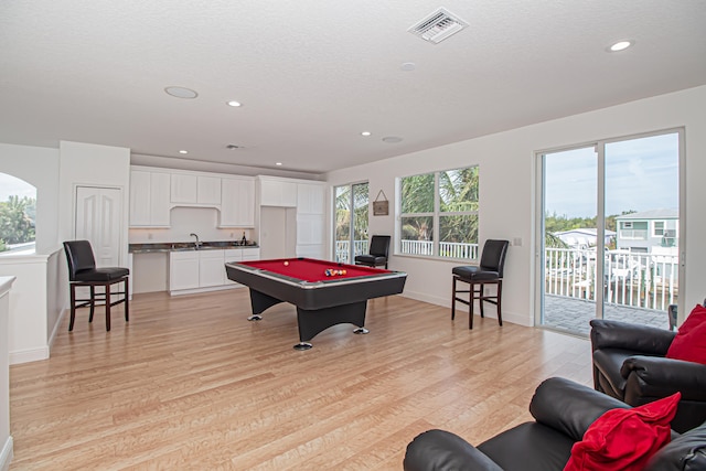 playroom with sink, a textured ceiling, light hardwood / wood-style flooring, and pool table