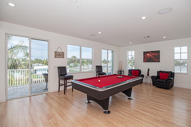 playroom featuring light hardwood / wood-style flooring, a textured ceiling, and billiards