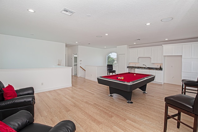 recreation room with light hardwood / wood-style floors, a textured ceiling, sink, and pool table