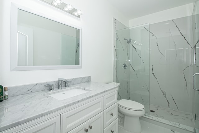 bathroom featuring vanity, toilet, and a shower with shower door