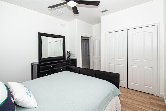 bedroom with light hardwood / wood-style floors, a closet, and ceiling fan