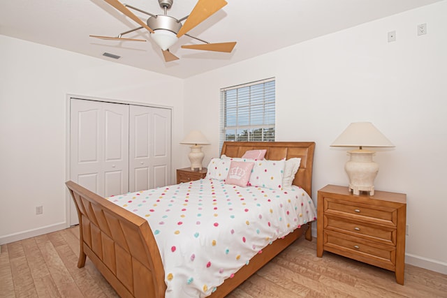 bedroom with a closet, light hardwood / wood-style floors, and ceiling fan