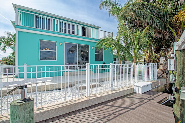 view of front of home with a patio, a fenced in pool, and a balcony