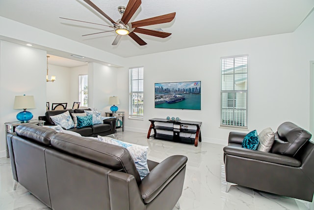 living room featuring ceiling fan with notable chandelier