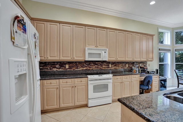 kitchen with built in desk, white appliances, crown molding, dark stone counters, and light tile patterned flooring