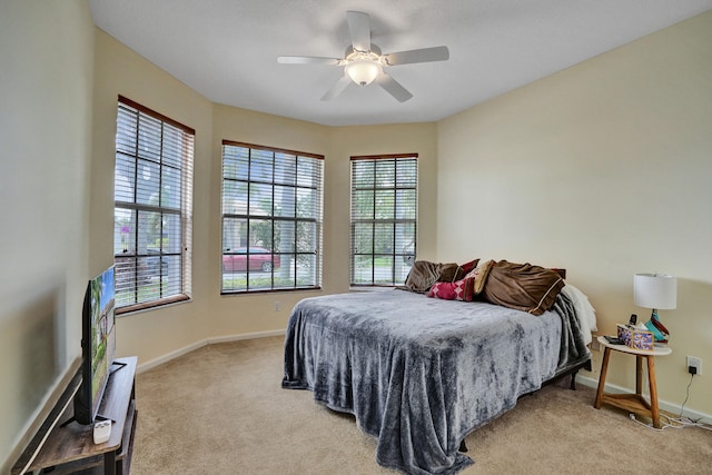 bedroom with ceiling fan and light carpet