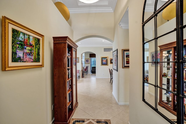 hallway with ornamental molding and light tile patterned floors