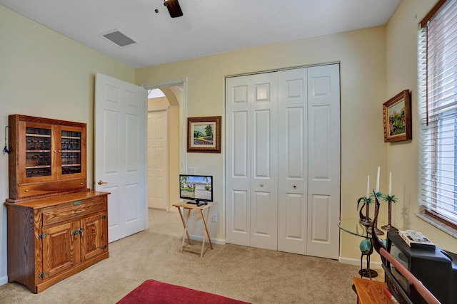 interior space featuring light carpet and ceiling fan