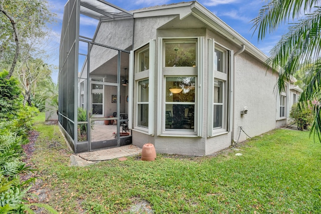 rear view of property featuring a lawn and a lanai