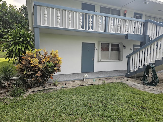 36 Islewood B, Deerfield Beach, FL 33442 - property entrance featuring a yard, stucco siding, and a balcony