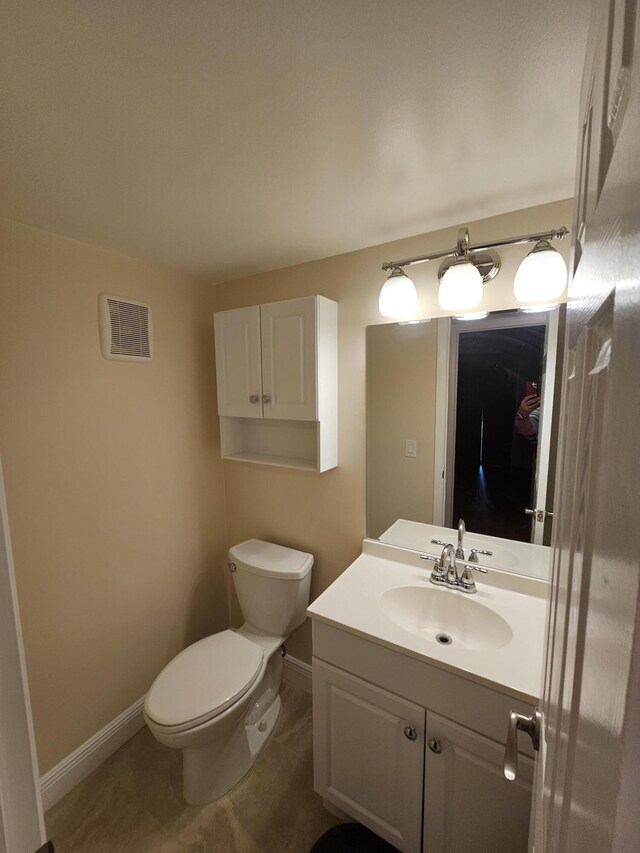 bathroom with vanity, toilet, and tile patterned floors