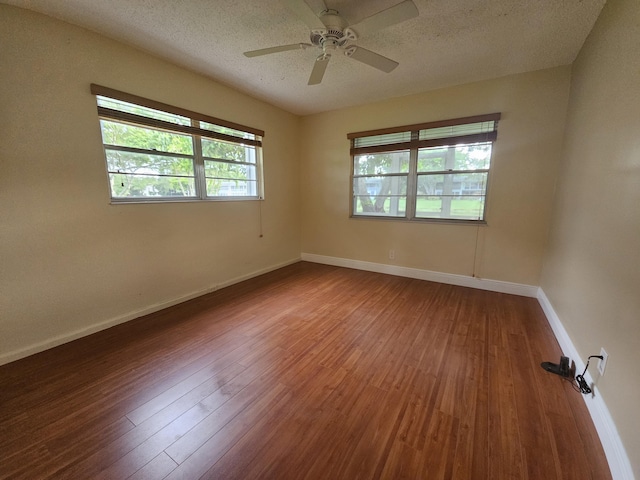 unfurnished room with ceiling fan, wood-type flooring, and a textured ceiling