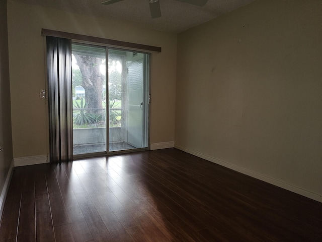 spare room featuring ceiling fan, dark hardwood / wood-style floors, and a textured ceiling