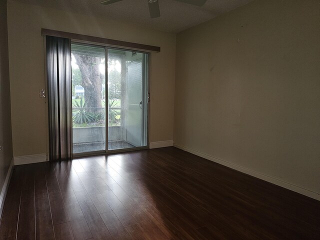 36 Islewood B, Deerfield Beach, FL 33442 - empty room featuring a ceiling fan, baseboards, and dark wood-style floors