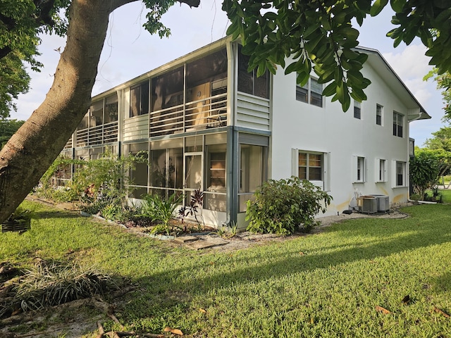 rear view of property featuring a yard and a sunroom