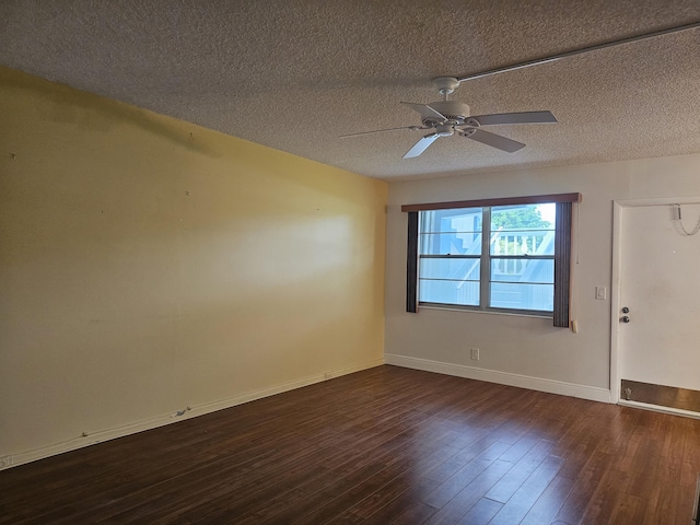 empty room featuring dark hardwood / wood-style flooring, ceiling fan, and a textured ceiling