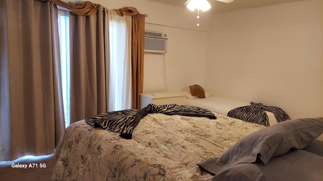 bedroom with ceiling fan and a wall mounted air conditioner