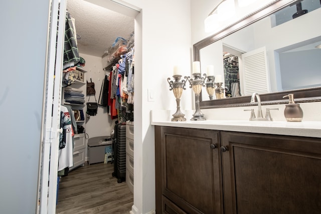 bathroom with wood-type flooring, a textured ceiling, and vanity