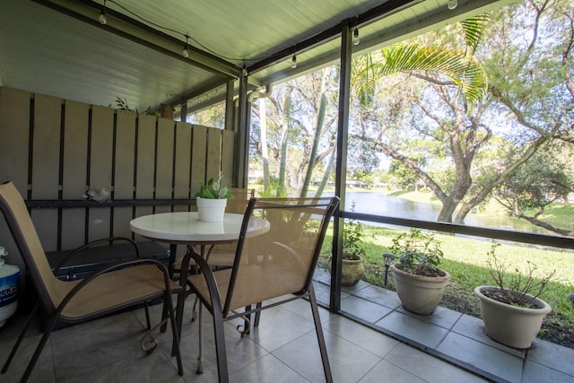 sunroom featuring plenty of natural light and a water view