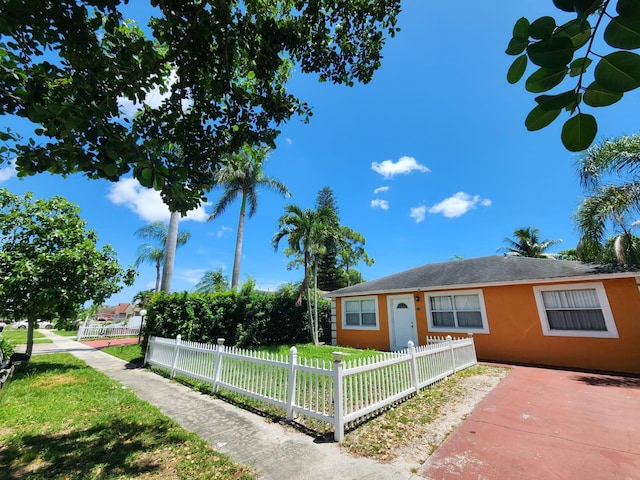 view of front facade with a fenced front yard, stucco siding, and a front yard