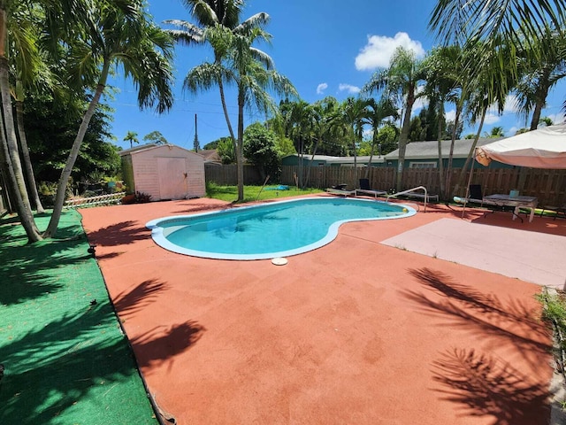 view of pool with a fenced in pool, a shed, a fenced backyard, an outdoor structure, and a patio