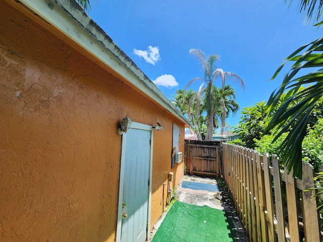 view of home's exterior with fence and stucco siding