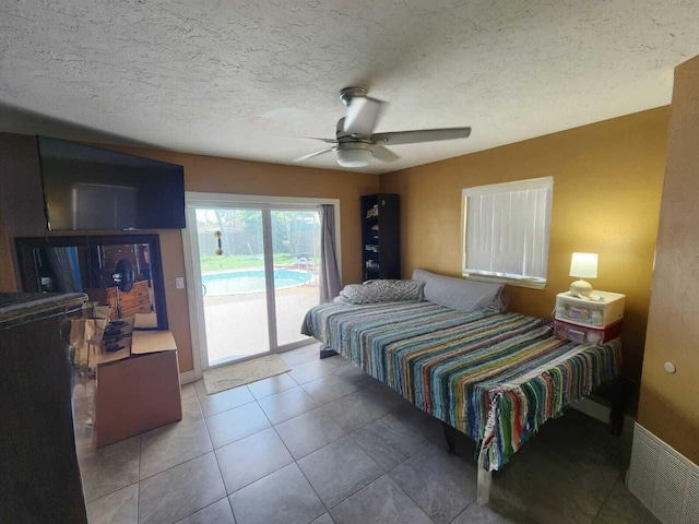 tiled bedroom featuring a textured ceiling, ceiling fan, and access to outside