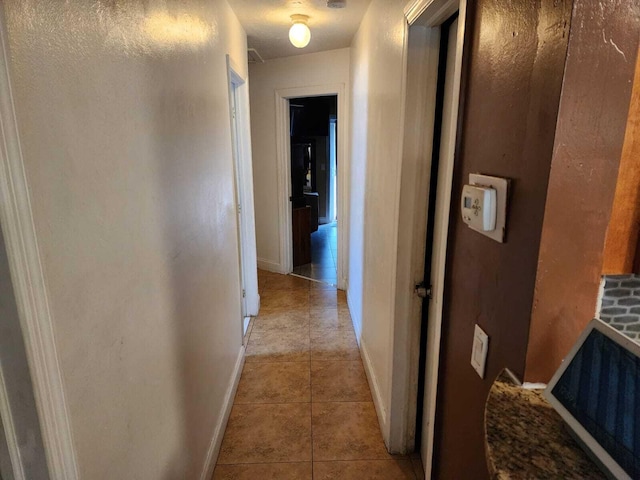 hallway featuring light tile patterned flooring and baseboards