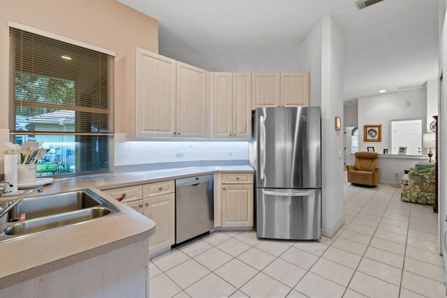 kitchen featuring appliances with stainless steel finishes, light brown cabinetry, light tile patterned floors, and sink