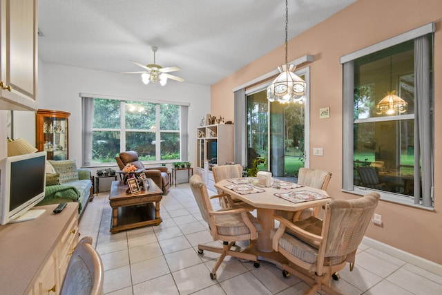 dining room with ceiling fan with notable chandelier, a textured ceiling, and light tile patterned floors